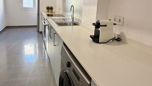 Uma cozinha moderna com eletrodomésticos de aço inoxidável, micro-ondas embutido e máquina de lavar roupa.