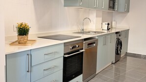 Uma cozinha moderna com armários azul claro, eletrodomésticos de aço inoxidável e piso em mosaico.