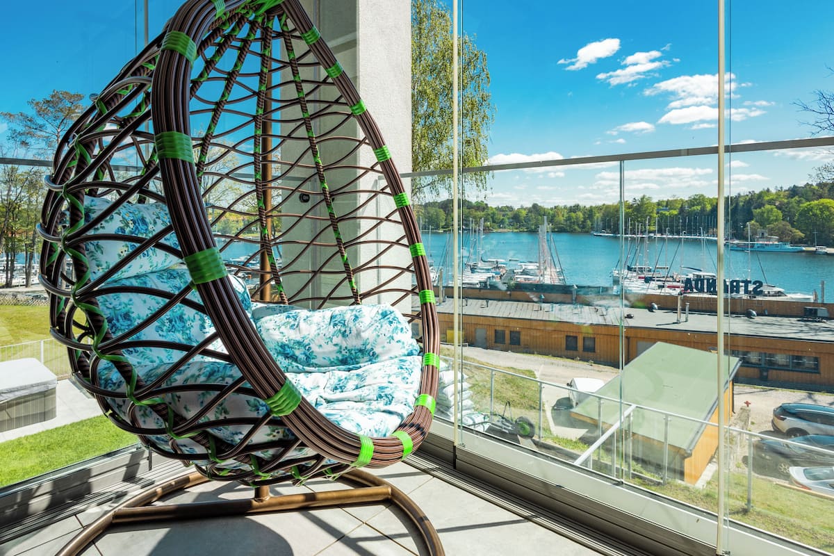 A modern chair with a geometric design, a view of a marina with boats, and a clear sky.