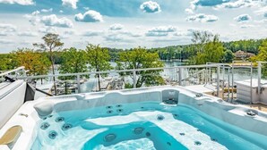 Un jacuzzi con vistas a un lago y barcos amarrados.