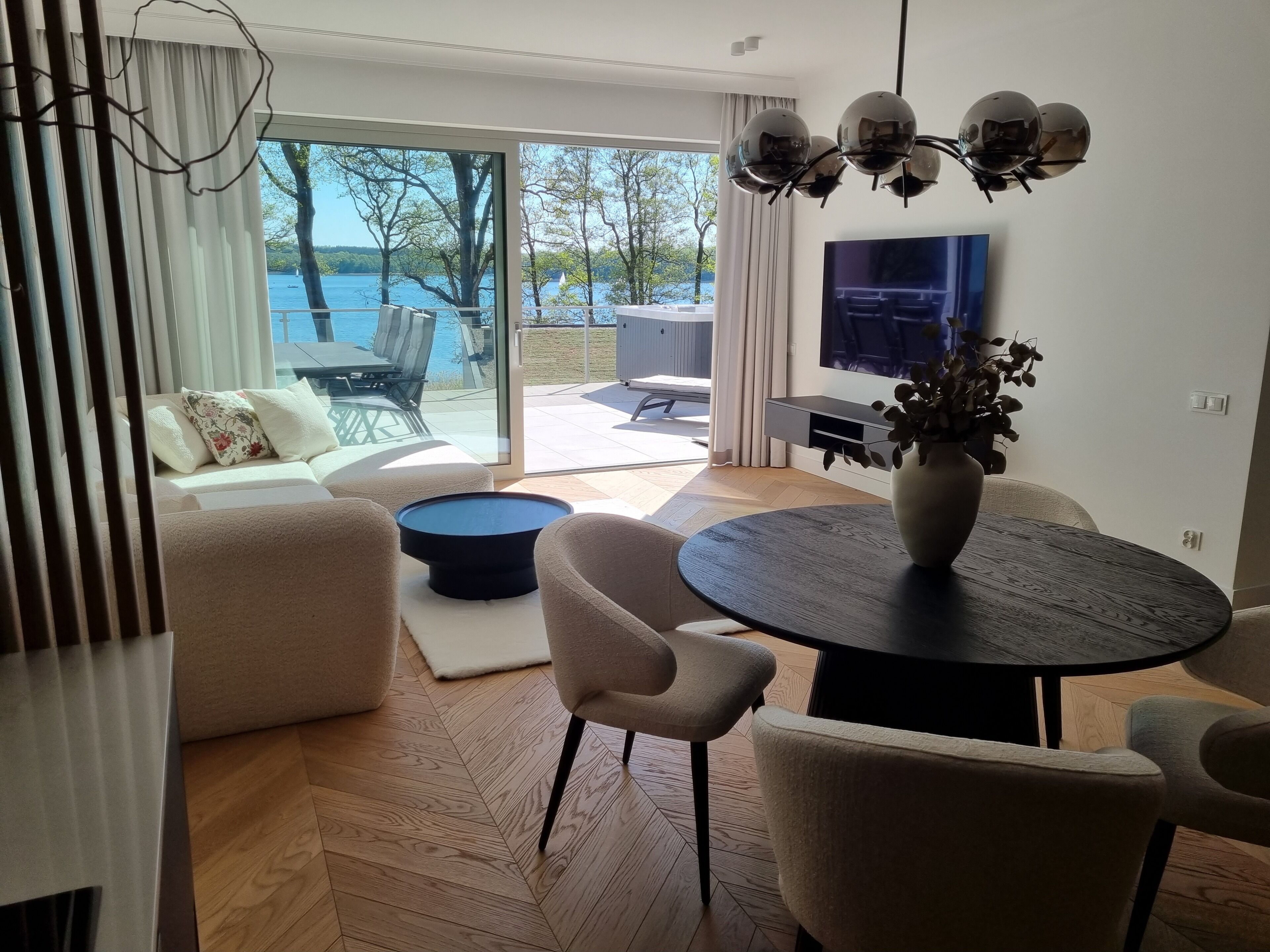 Een moderne woonkamer met een bank, een ronde tafel en een televisie.