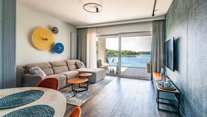 Una sala de estar moderna con un sofá, un televisor y vistas a un lago.