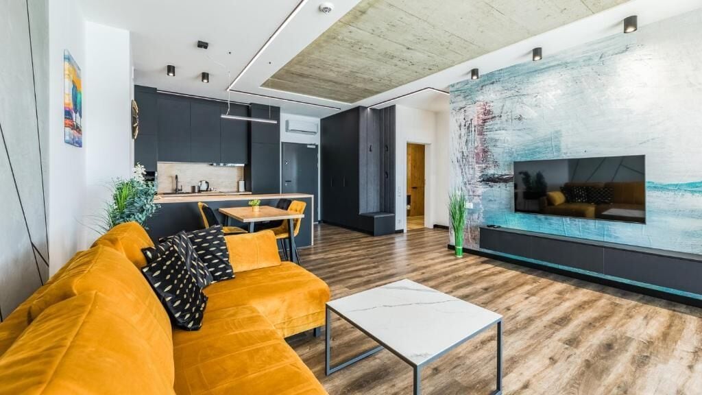 Ein modernes Wohnzimmer mit einer Couch, einem Couchtisch und einem großen abstrakten Gemälde an der Wand.