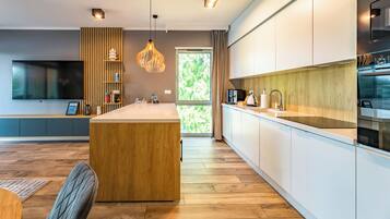 Una cocina moderna con una isla central, paneles de madera y un amplio ventanal.