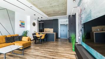 Ein modernes Wohnzimmer mit Sofa, Couchtisch und einem Essbereich mit Stühlen.