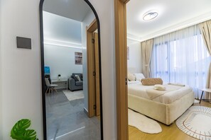 Une chambre d’hôtel moderne, équipée d’un lit, d’un bureau et d’une chaise.