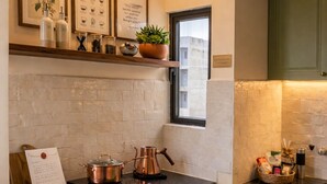 Una cocina con gabinetes verdes, una estación de café y una ventana con vistas.