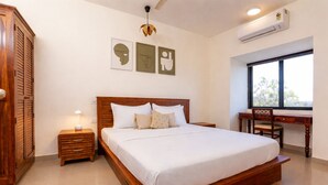 Un dormitorio con una cama de madera, mesitas de noche, un escritorio y una silla.