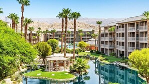Ein Resort mit mehreren Gebäuden, einem Swimmingpool und Palmen.