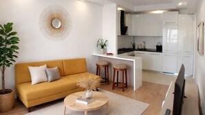 Ein modernes Wohnzimmer mit Sofa, Couchtisch und Fernseher.