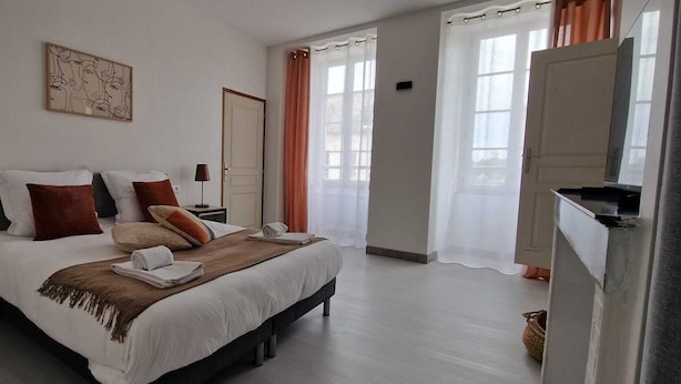 Une chambre à coucher avec un lit, des tables de chevet, une lampe, un tableau et une porte.