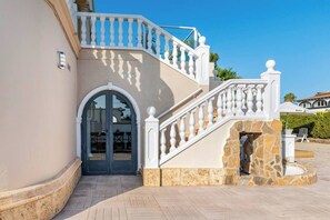 A multi-level building with a stone staircase, an arched entrance, and a balcony. - Villa in Calpe near the beach (Calpe)