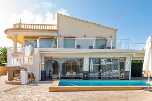 A two-story house with a glass-enclosed balcony, a stone fireplace, and a swimming pool. - Villa in Calpe near the beach (Calpe)