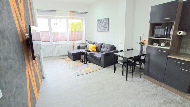 Eine moderne Wohnung mit Wohnzimmer, Essbereich und Küche.