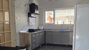 A modern kitchen with a built-in stove, stainless steel cabinets, and a refrigerator. - Room-cozy Room Near Airport (Perth)