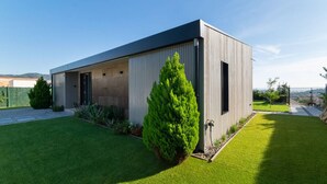 A modern building with a flat roof, a large open garage door, and a well-maintained lawn.