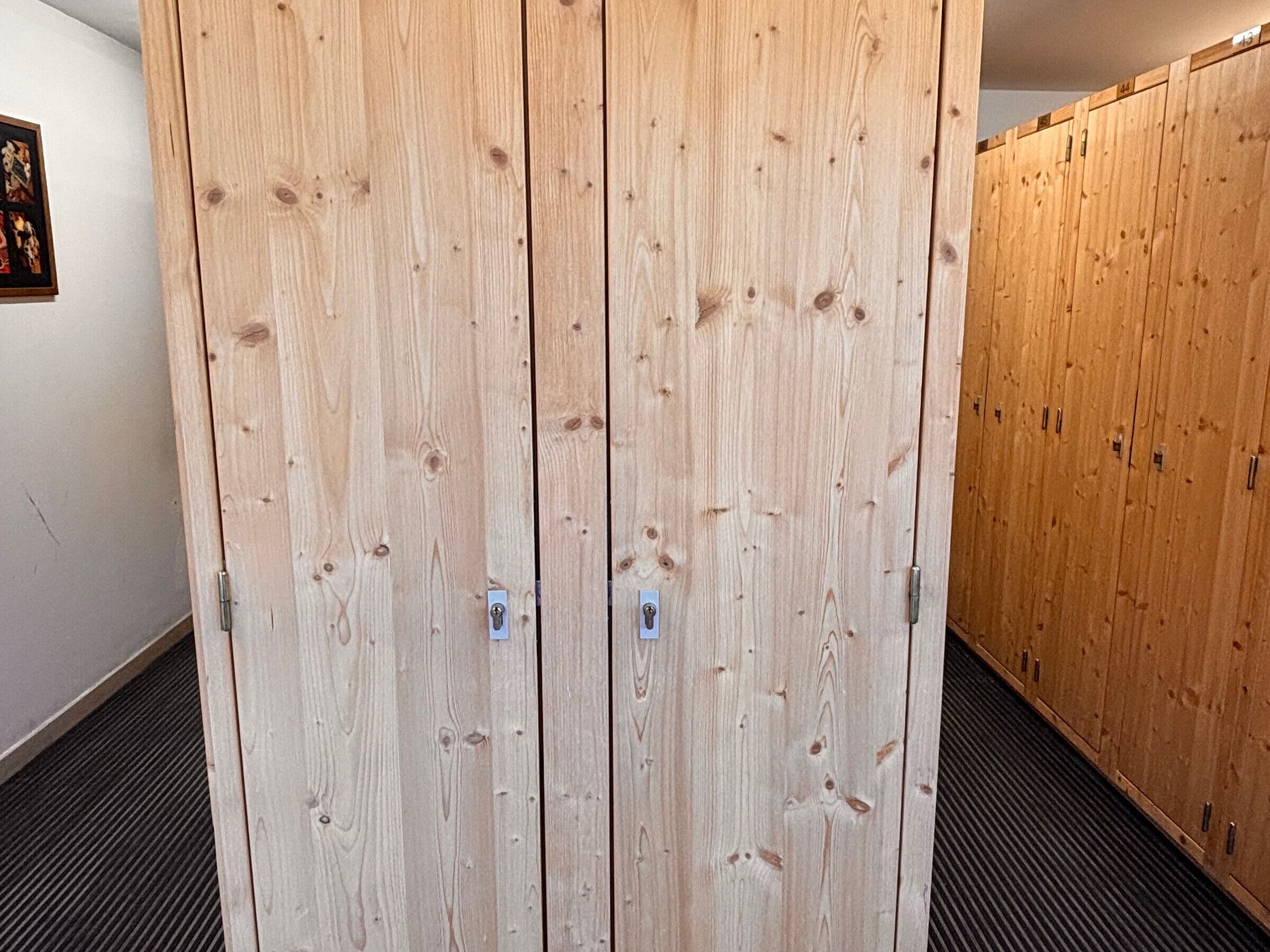 Une rangée de casiers en bois dans un couloir.