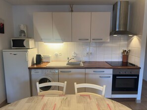 Eine kleine Küche mit Mikrowelle, Toaster, Spüle und Backofen.