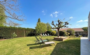 A well-maintained backyard with a lawn, a tree, and a wooden deck. - Spacious house near beaches - 12 guests (Challans)