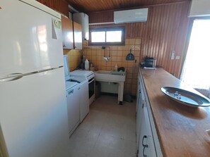 A compact kitchen with a refrigerator, stove, sink, and a window above the counter. - Apartment 150m from the beach - 6 guests (Argelès-sur-Mer)