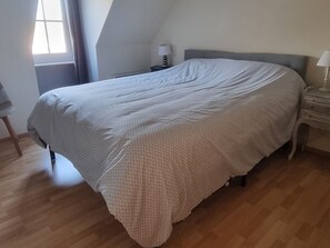 A bedroom with a bed, a nightstand, a lamp, and a window. - Quiet house in sought-after area - 4 guests (Quend)