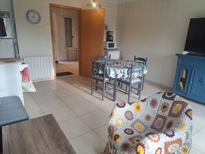 A living room with a dining table, chairs, a TV, and a blue cabinet. - Quiet house in sought-after area - 4 guests (Quend)