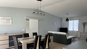 Ett modernt kök med en matplats, en soffa och en TV.