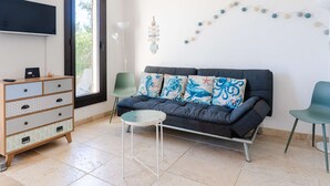 A living room with a sofa, two chairs, a small table, a TV, a dresser, and a window. - Cozy pavilion with parking - 4 guests (Gruissan)
