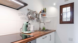 A modern kitchen with a coffee machine, kettle, and various utensils on the wall. - Cozy pavilion with parking - 4 guests (Gruissan)