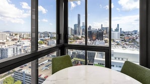 Habitación en un edificio alto con un amplio ventanal que ofrece vistas a la ciudad.