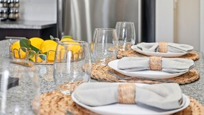A neatly set dining table with plates, glasses, and lemons.