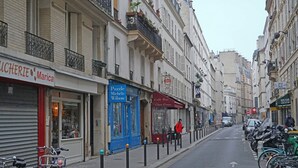 A narrow street lined with closed shops, a café bar, and parked bicycles. - La Folie Urban Studio R Publique Marais Canal St Martin (Paris)