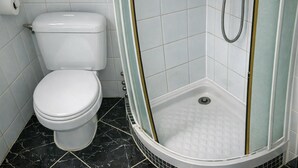 A bathroom with a toilet, a shower with a glass door, and a tiled floor. - La Folie Urban Studio R Publique Marais Canal St Martin (Paris)