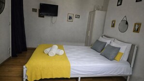 A single bed with a yellow blanket, white bedding, and two pillows. - La Folie Urban Studio R Publique Marais Canal St Martin (Paris)