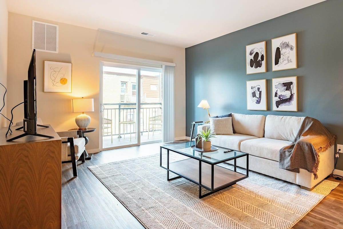 A modern living room with a sofa, coffee table, and artwork on the wall.