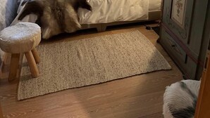 Makuuhuoneessa on sänky, puinen kaappi ja ikkuna, jossa on sälekaihtimet.