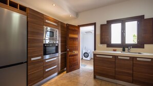 Eine moderne Küche mit Holzschränken, Edelstahlgeräten und einem eingebauten Backofen.