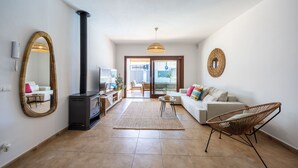 Ein Wohnzimmer mit Kamin, Sofa, Sessel und einem großen Spiegel.