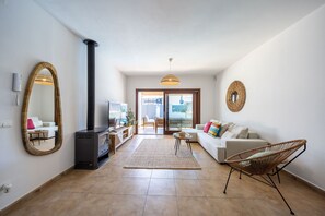 A living room with a fireplace, sofa, chair, and a large mirror. - Casa Victoria | Ibiza town 5 min (Islas Baleares)