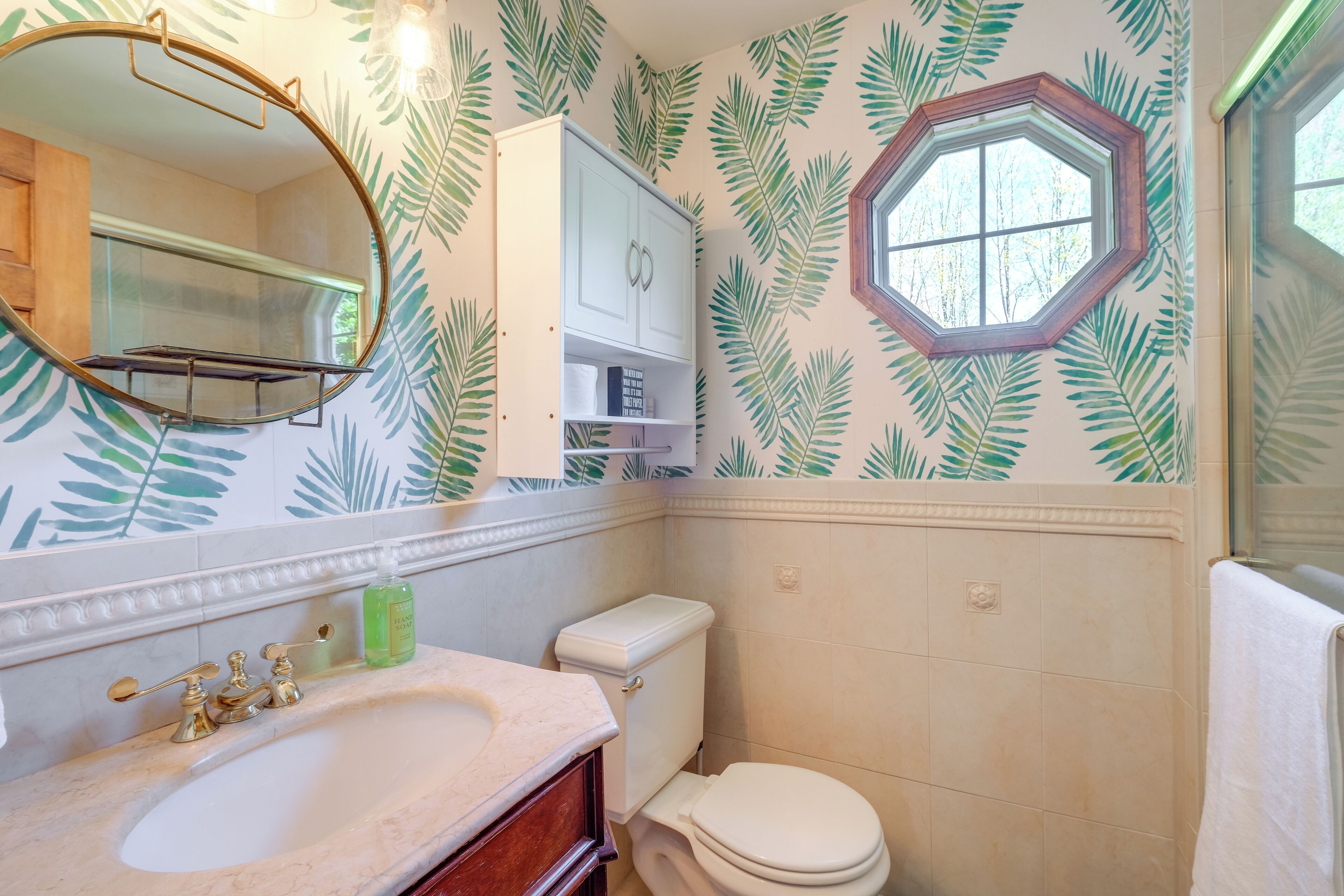 Een badkamer met een wastafel, toilet en spiegel.