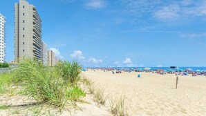 Une plage de sable avec de grands immeubles en arrière-plan.