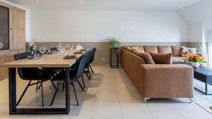 Um interior moderno com uma área de refeições, um sofá e uma planta.