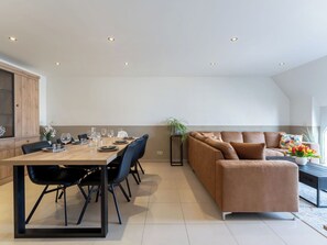 Ein modernes Interieur mit Essbereich, einer Couch und einer Pflanze.