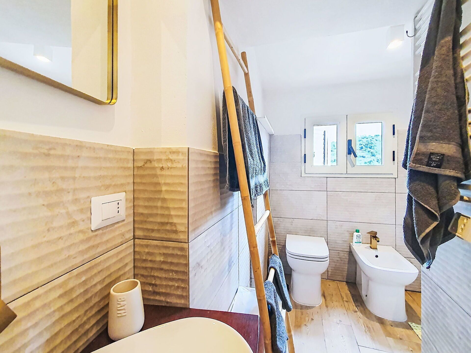 A bathroom with a toilet, bidet, and a mirror.
