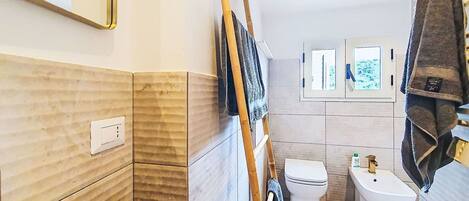 A bathroom with a toilet, bidet, and a mirror.