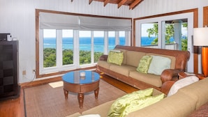 A living room with a sofa, a coffee table, and a television. - Top Ridge Views 2 Bedroom Home (Roatan)
