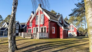 Punainen talo, jossa on valkoinen kuisti ja savupiippu.