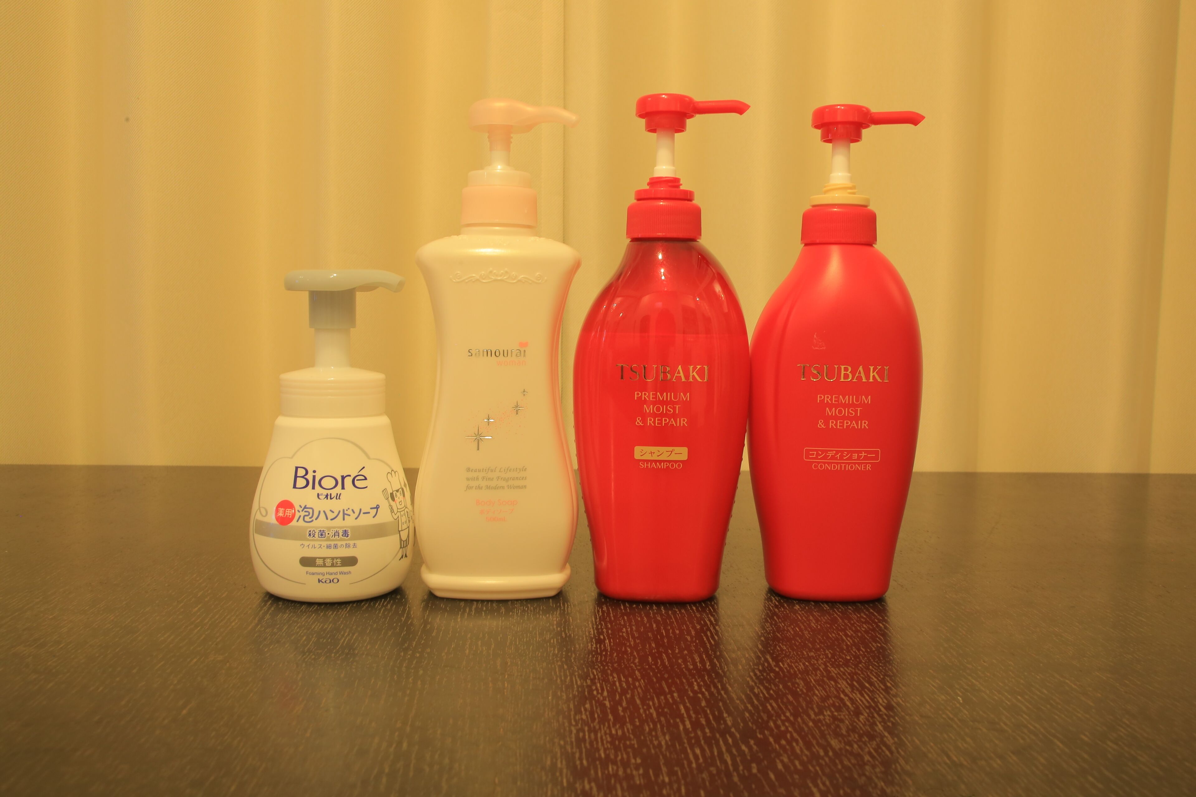 Four bottles of personal care products on a table.