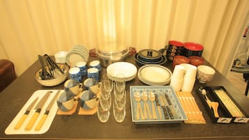 A table set with various dishes, utensils, and glassware, indicating a dining setup.