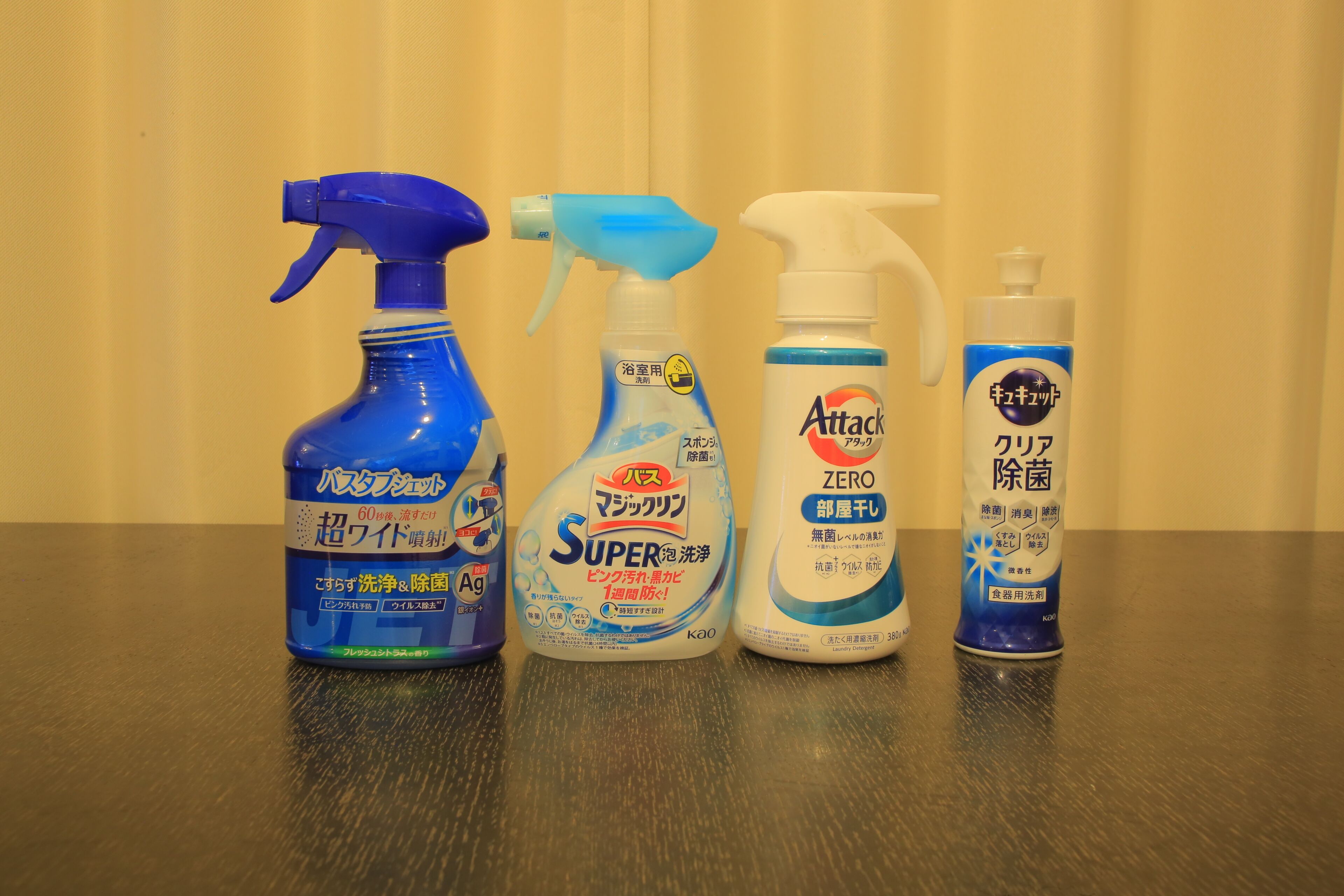 Four bottles of cleaning products on a table.